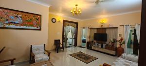 a living room with a couch and a tv at S R Villa Mysore in Mysore