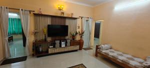 a living room with a television and a couch at S R Villa Mysore in Mysore