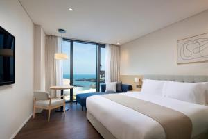 Postel nebo postele na pokoji v ubytování Shilla Stay Plus Iho Tewoo Ocean Front