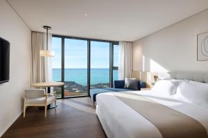 Postel nebo postele na pokoji v ubytování Shilla Stay Plus Iho Tewoo Ocean Front