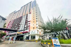 ein hohes Gebäude mit einem Schild davor in der Unterkunft RedLiving Apartemen kemang View - My Room LapanLapan Tower Mahagoni in Pekayon Satu