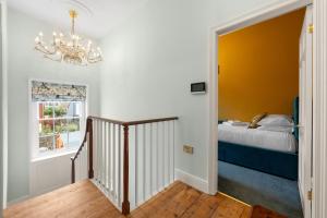 a bedroom with a bed and a chandelier at Luxury Georgian home, hot tub, sea view, private garden, sleeps 6 in Bognor Regis
