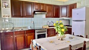 una cucina con un tavolo e un frigorifero bianco di YELLOW HOUSE a Cefalù