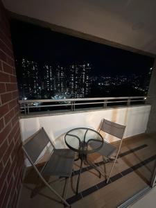 einen Tisch und 2 Stühle auf dem Balkon mit Blick auf die Skyline der Stadt in der Unterkunft DEPA EN SONATA 3 habitaciones in Santa Clara Ocoyucan