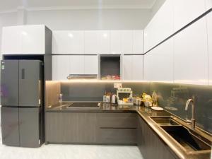 a kitchen with a stainless steel refrigerator and a sink at Hidden Bungalow in Buôn Enao