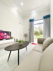 a living room with a couch and a table at Hidden Bungalow in Buôn Enao