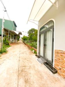a dirt road next to a house with a door at Hidden Bungalow in Buôn Enao