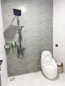 a bathroom with a white toilet and a shower at Hidden Bungalow in Buôn Enao +7 photos