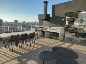 Un patio con una mesa y sillas en un tejado. en Hermoso y moderno departamento, nuevo, a pasos de la Quinta Vergara, cercano a los mejores atractivos de viña del mar, con maravillosa vista, en Viña del Mar