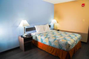 a hotel room with a bed and two lamps at Motel 6 Litchfield, IL in Litchfield