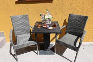 two chairs and a table with a bowl of flowers on it at Georgescu House in Făgăraş