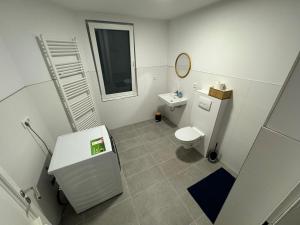 a white bathroom with a toilet and a sink at Big House I 15 Beds I 8 Sleeping Room I Parking in Bad Oeynhausen +13 photos