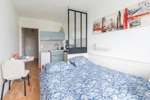 ein kleines Schlafzimmer mit einem Bett und einer Küche in der Unterkunft Le Ptit Henri - Studio à 20min de Paris in LʼHay-les-Roses
