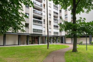 ein Mehrfamilienhaus mit einem Park davor in der Unterkunft Le Ptit Henri - Studio à 20min de Paris in LʼHay-les-Roses