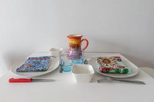 einem Tisch mit zwei Platten, einer Vase und einer Brille in der Unterkunft Le Ptit Henri - Studio à 20min de Paris in LʼHay-les-Roses + 2 Fotos