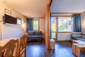 Habitación con cama, sofá y ventana en Appartement 4p, en Méribel