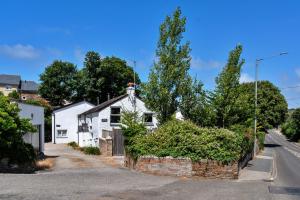 Ein weißes Haus an der Seite einer Straße in der Unterkunft Finest Retreats - Porth Cottage in Newquay