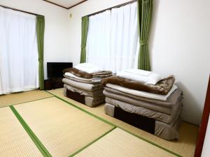 a living room with two stacks of pillows and a television at Casa Tatsugaoka - Vacation STAY 93133v in Fujiyoshida