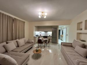 a living room with couches and a table and a kitchen at La Esquina Central in Iraklitsa