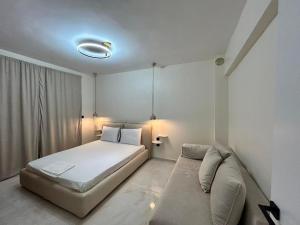 a bedroom with a large bed and a couch at La Esquina Central in Iraklitsa