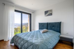a bedroom with a bed and a large window at Villa Toci in Calcatoggio +30 photos