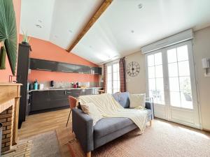un soggiorno con divano e cucina di Jolie Maison La Havane avec terrasse plein sud a Vichy Altre 2 foto