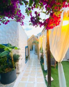 a walkway with bougainvilleas on a white building at Badehan Guest House in Cesme