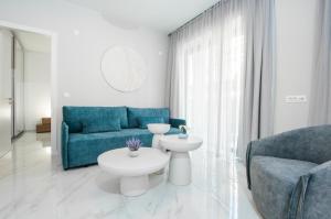 a living room with a blue couch and a table at Oikos luxury central apartment in Agios Nikolaos