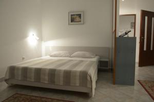 a bedroom with a bed and a dresser in it at Apartments Villa Ypsilon in Sveta Nedelja