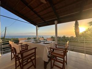 a dining room with a table and chairs on a balcony at Villa Naturaleza in Loutsa