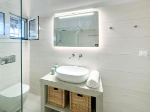 a white bathroom with a sink and a mirror at Villa Naturaleza in Loutsa +21 photos