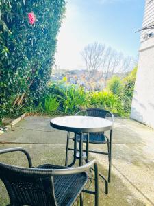 dos sillas y una mesa y una mesa y sillas en Ball Place Residence-Enjoy the entire downstairs, en Auckland