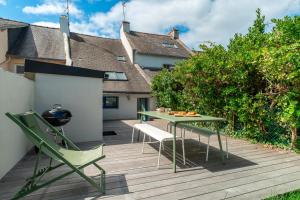 a patio with a table and chairs on a deck at La Petite Maison du Pêcheur - Proche plage pour 5p in Sarzeau