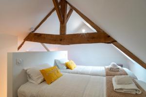a bedroom with a white bed with yellow pillows at La Petite Maison du Pêcheur - Proche plage pour 5p in Sarzeau