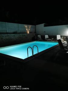 a swimming pool at night with two bars in it at Casa Ilici in Sviniţa