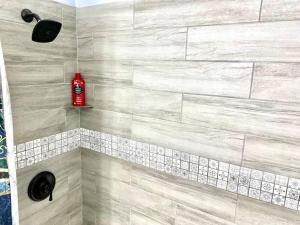 a bathroom with a shower with a red bottle of shampoo at Welcome International Guests-Medical Residents-free shuttle downtown-full kitchen- free parking in Memphis