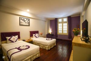 Postel nebo postele na pokoji v ubytování TTC Hotel - Ngoc Lan + 37 fotografií