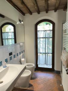 a bathroom with a toilet and a sink and a window at La casina nella fattoria in Siena