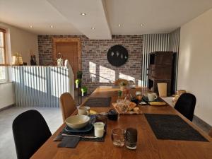 a wooden table with chairs and a dining room at Gîte l'Enclos Ô rendez-vous Roquefeuil-Pays de sault- avec jardin in Roquefeuil