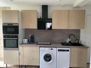 a kitchen with a washing machine in a kitchen at Superbe appartement calme in Chenaud