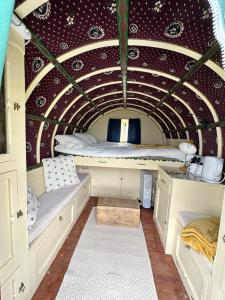 LlangrannogGypsy bow top caravan的小房间,带一张位于隧道内的床铺