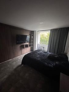 une chambre avec un lit noir et une fenêtre dans l'établissement Hermosa casa con hermosas amenidades y cuartos zona universitaria con luxxury amanecer con vista, à Lomas de Angelopolis