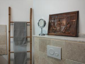 a mirror sitting on top of a stone fireplace at gîte Couleur Cuivre in Cerdon