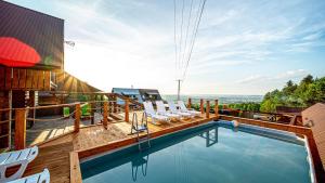 a swimming pool with lounge chairs on a building at Trzy Kopce in Ropica Dolna