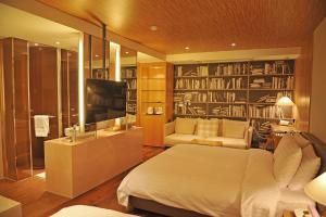 a bedroom with a bed and a tv and books at Grammos Hotel in Seoul
