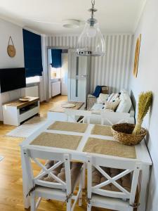salon z białym stołem i kanapą w obiekcie Apartament Łazienna River View AC Progres w Toruniu
