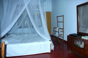una camera con letto a baldacchino e TV di Abberny villa a Midigama East