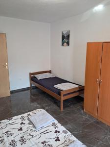 a bedroom with a bed and a cupboard and a bed at Apartments Mara Bela in Karlobag