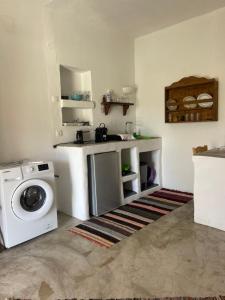 kuchnia z pralką i zlewem w obiekcie Venereum Apartments w mieście Faros