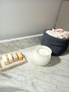 un bloc de fromage et un bol sur un comptoir dans l'établissement petite maison avec jardin calme, au Thor